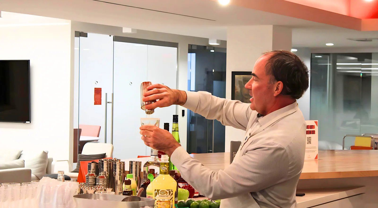 Mixologist demonstrating a cocktail pour in an office lounge