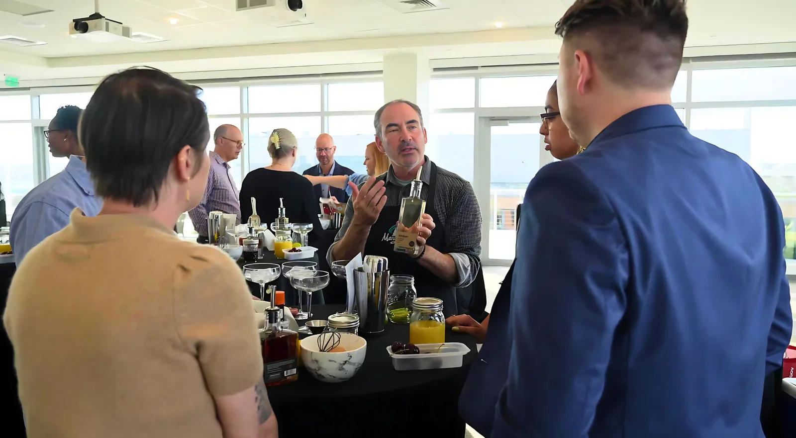 Mixologist leading a team through a cocktail class at an event space